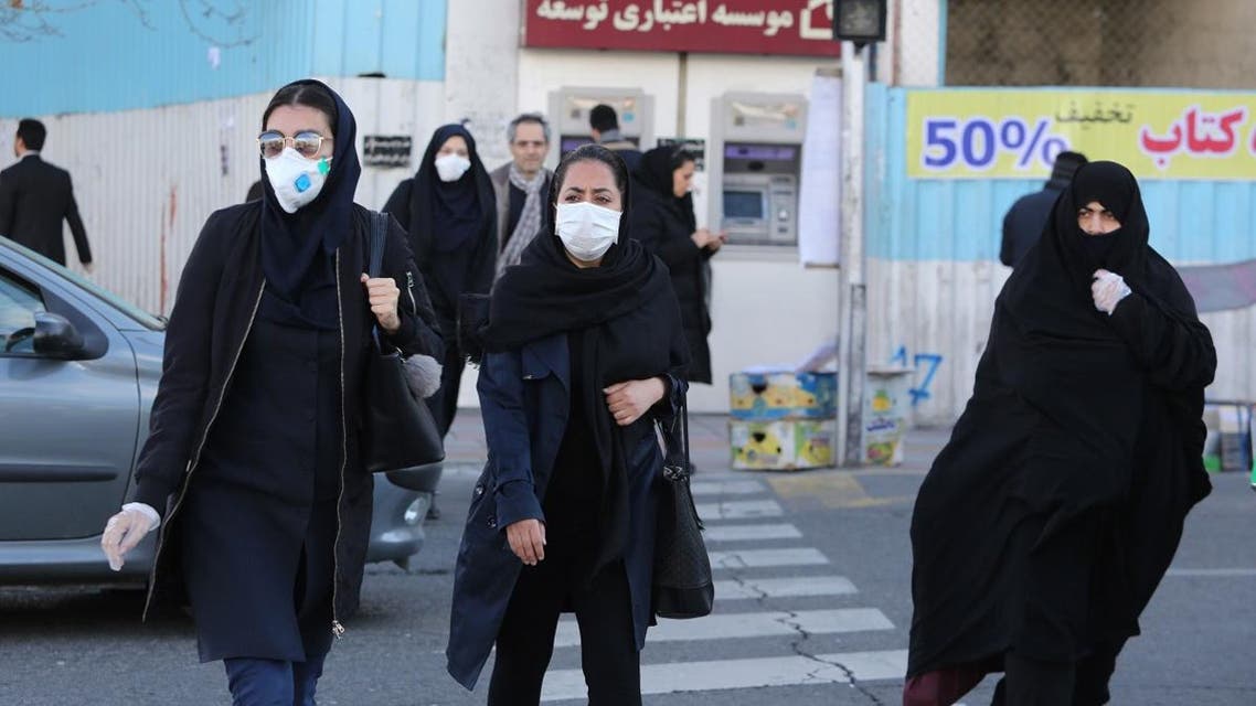 Women wearing protective masks cross a street in the Iranian capital Tehran on March 2, 2020, following the coronavirus outbreak. (AFP)