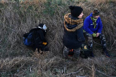 Migrants rest in a ditch, after crossing from Turkey to Greece, near the border crossing of Kastanies. (Reuters)