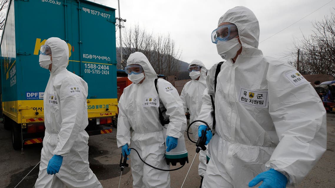 South Korean soldiers wearing protective gears walk to spray disinfectant as a precaution against the coronavirus in Seoul, South Korea on March 3, 2020. (AP)