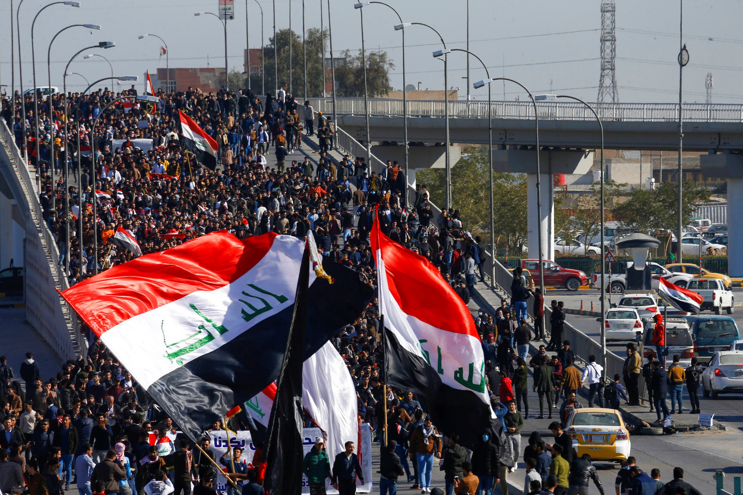 University students hold Iraqi flags during ongoing anti-government protests in Najaf, Iraq January 12, 2020. (Reuters)