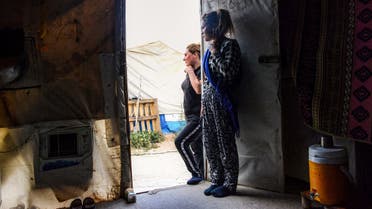 Women stand through the doorway of a tent shelter equipped with air-conditioning at a camp for internally displaced persons (IDP) of Iraq's Yazidi minority in the Sharya area, some 15 kilometres from the northern city of Dohuk in the autonomous Iraqi Kurdistan region on August 30, 2019.