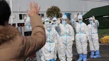 Medical personnel in protective suits wave hands to a patient who is discharged from the Leishenshan Hospital after recovering from the coronavirus, in Wuhan, in Hubei province, China, March 1, 2020. (Reuters)