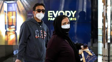 People wearing face masks shop in northern Tehran on March 3, 2020. (AP)