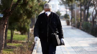 An Iranian man wears a protective mask to prevent contracting coronavirus, as he walks on a street in Tehran, Iran. (Reuters)