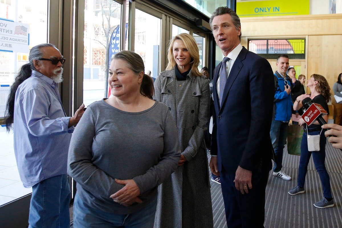California Governor Gavin Newsom (right), waits in line to vote with his wife, Jennifer Siebel Newsom, second from right, on Super Tuesday in Sacramento, California, on March 3, 2020. (AP)