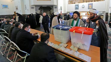 Iranian election officials wear masks as they wait for voters during parliamentary elections at the Shah Abdul Azim shrine on the southern outskirts of Tehran on February 21, 2020. Iran's health ministry today reported two more deaths among 13 new cases of coronavirus in the Islamic republic, bringing the total number of deaths to four and infections to 18.