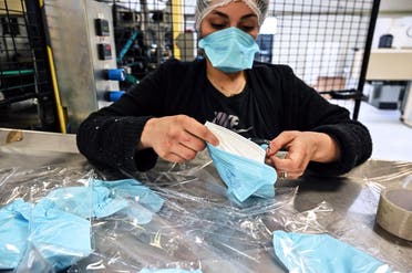 An employee packs respiratory protective face masks in Mably, central France, on February 28, 2020, amid the spread of the novel coronavirus. (AFP)
