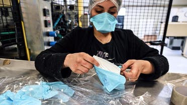 An employee packs repiratory protective face masks on an assembly line at the Valmy protective mask manufacturer plant in Mably, central France, on February 28, 2020, amid the spread of the novel coronavirus. (AFP)