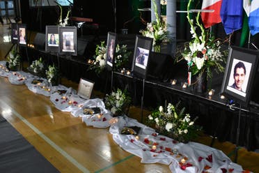 Mourners place flowers by photos of the victims, before the start of a memorial service for the Ukrainian Airlines flight PS752, in Edmonton, Canada on January 12, 2020. (AFP)