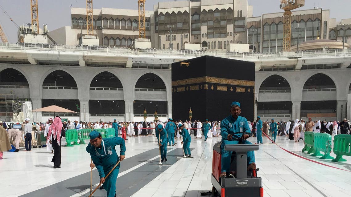 Workers clean the Grand Mosque, during the minor pilgrimage, in Saudi Arabia, March 2, 2020. (AP)