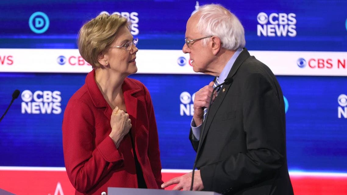 Democratic presidential candidates Sen. Elizabeth Warren (D-MA) (L) and Sen. Bernie Sanders (I-VT) interact during a break at the Democratic presidential primary debate at the Charleston Gaillard Center on February 25, 2020 in Charleston, South Carolina. (AFP)