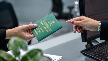 A Saudi woman receives her newly-issued passport at the Immigration and Passports Centre in the capital Riyadh on August 29, 2019. Saudi Arabia has eased travel restrictions on women, allowing those aged over 21 to obtain passports without seeking the approval of their guardians -— fathers, husbands or other male relatives, but observers say loopholes still allow male relatives to curtail their movements and, in the worst cases, leave them marooned in prison-like shelters.