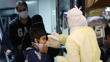 Passengers coming from China wearing masks to prevent a new coronavirus are checked by Saudi Health Ministry employees upon their arrival at King Khalid International Airport, in Riyadh, Saudi Arabia. (Reuters)