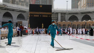 Cleaners wear protective face masks, following the outbreak of the coronavirus, as they swipe the floor at the Kaaba in the Grand mosque in the holy city of Mecca, Saudi Arabia, March 3, 2020. (Reuters)