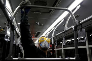 A Tehran Municipality worker cleans a bus to avoid the spread of the COVID-19 illness on February 26, 2020. (AFP)