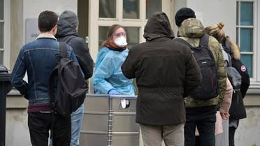 A medical employee talks with people waiting outside a new medical examination department in Berlin. (File photo: AFP)