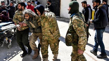 Turkey-backed opposition fighters help a fellow fighter wounded in fighting with Syrian government forces and their allies in Sarmin, south of Idlib on March 1, 2020. (AP)