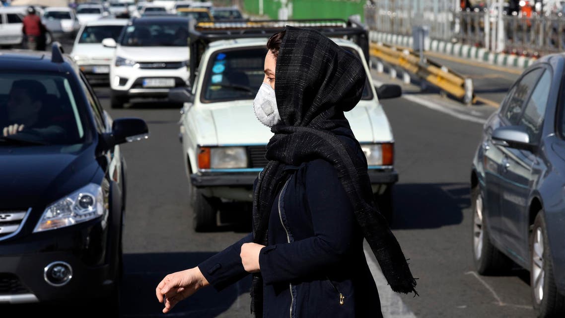 A woman wearing a face mask crosses an intersection in northern Tehran on March 4, 2020. (AP)