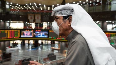 A Kuwaiti trader wears a protective face mask, following the outbreak of the new coronavirus, as he stands on the upper floor since the lower main hall is closed to traders at the Kuwait Boursa. (Reuters)