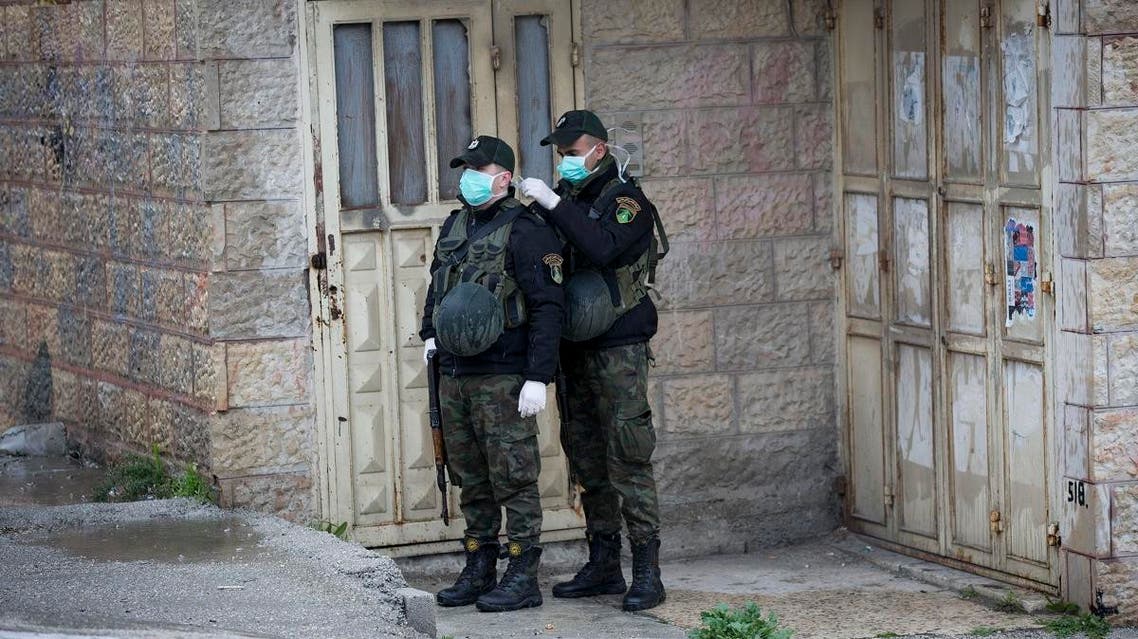 Members of Palestinian security forces wear masks as they stand guard outside a hotel which staff tested positive for coronavirus in Bethlehem, West Bank, Palestine (AP)