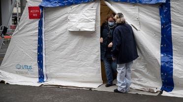 A nurse escorts a patient with covid-19 symptoms to a tent set up in a courtyard of the Henri Mondor Hospital in Creteil, near Paris. (Reuters)