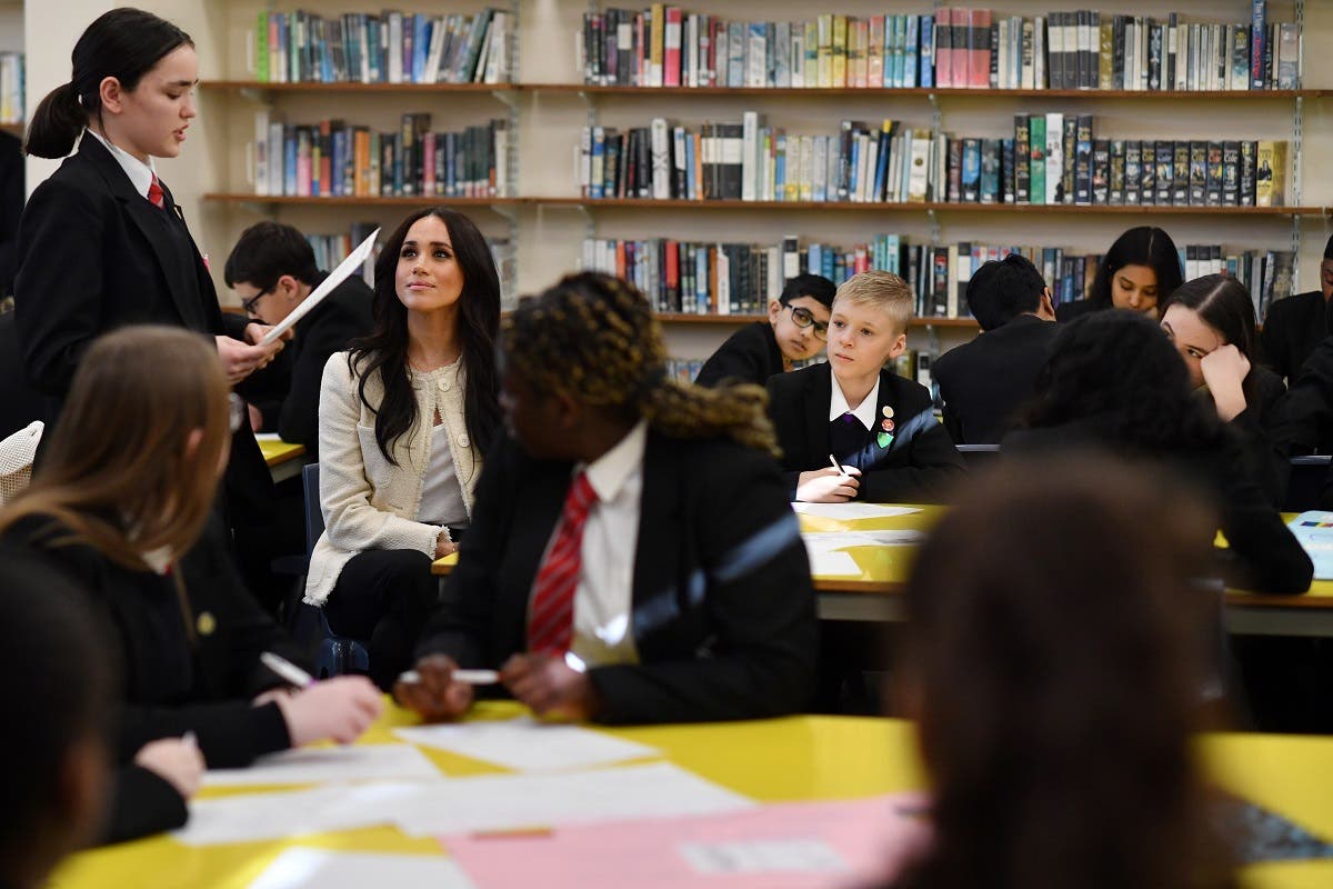 Britain’s Meghan, Duchess of Sussex, listens to a student reciting a poem during a visit to Robert Clack School in Essex, on March 6, 2020, in support of International Women’s Day. (AFP)