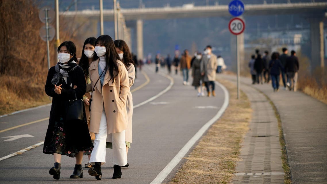 Women wearing masks to prevent contracting the coronavirus take a walk at a Han River park in Namyangju, South Korea, March 7, 2020. (Reuters)