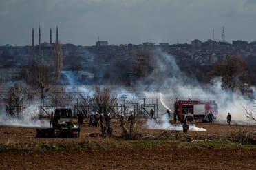 Greek soldiers and riot police officers stand stand amid clouds of tear gas at the Greece-Turkey border during clashes between migrants and riot police in the village of Kastanies on March 7, 2020. (AFP)