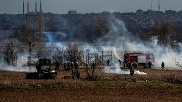 Greek soldiers and riot police officers stand stand amid clouds of tear gas at the Greece-Turkey border during clashes between migrants and riot police in the village of Kastanies on March 7, 2020. (AFP)