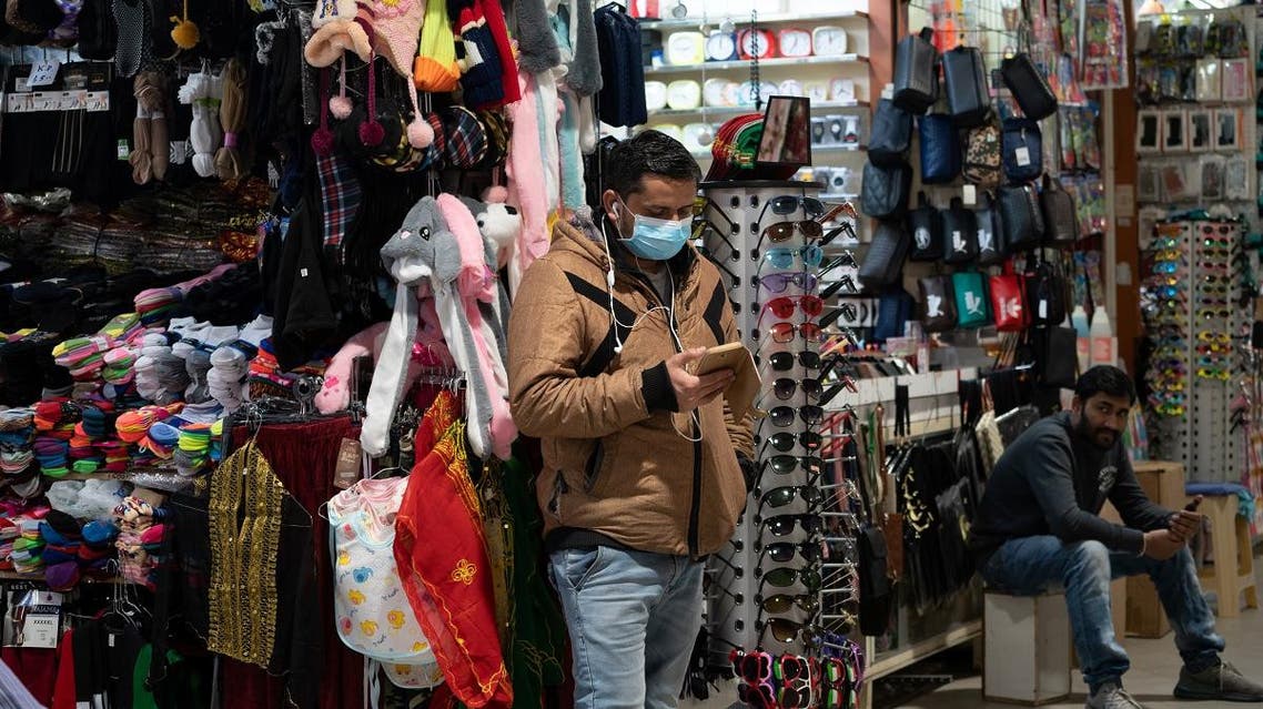 A man uses his phone as he wears a protective face mask, following the outbreak of the new coronavirus, in Kuwait, February 25, 2020. Picture taken February 25, 2020. (Reuters)