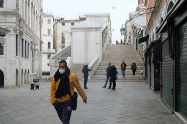 رجل يضع قناعاً واقياً في مدينة البندقية بإيطاليا يوم الاثنين