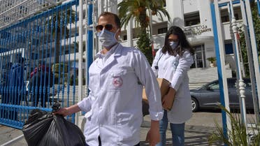 Emergency doctors and nurses who have been trained to handle the coronavirus disease cases, exit the Tunisian health ministry premises in the capital Tunis after collecting supplies on March 3, 2020. (AFP)