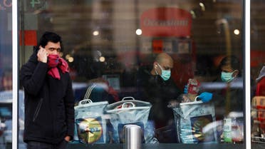 A person talks on the phone while people are shopping in a supermarket to stock up on food and goods, after a decree orders for the whole of Italy to be on lockdown in an unprecedented clampdown aimed at beating the coronavirus, in Rome, Italy, March 10, 2020. (Reuters)
