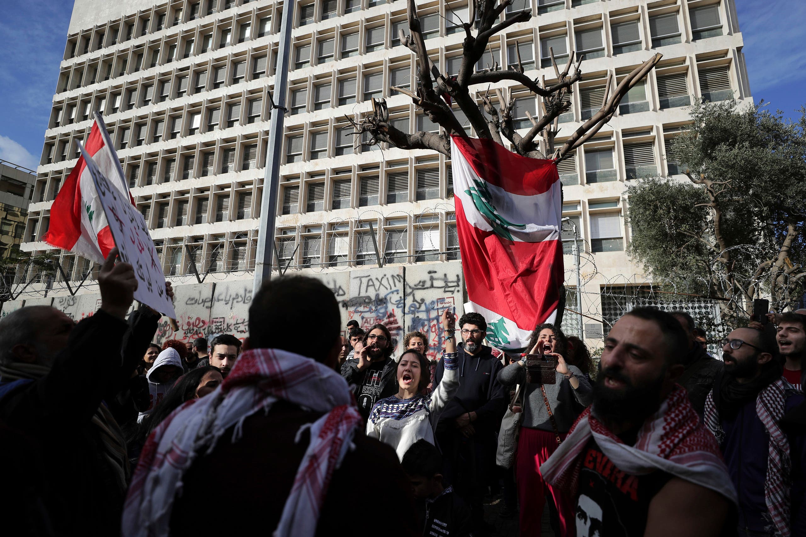 Anti-government protesters chant slogans, during ongoing protests against the Lebanese government in front of the Central Bank in Beirut on Feb. 1, 2020. (AP)