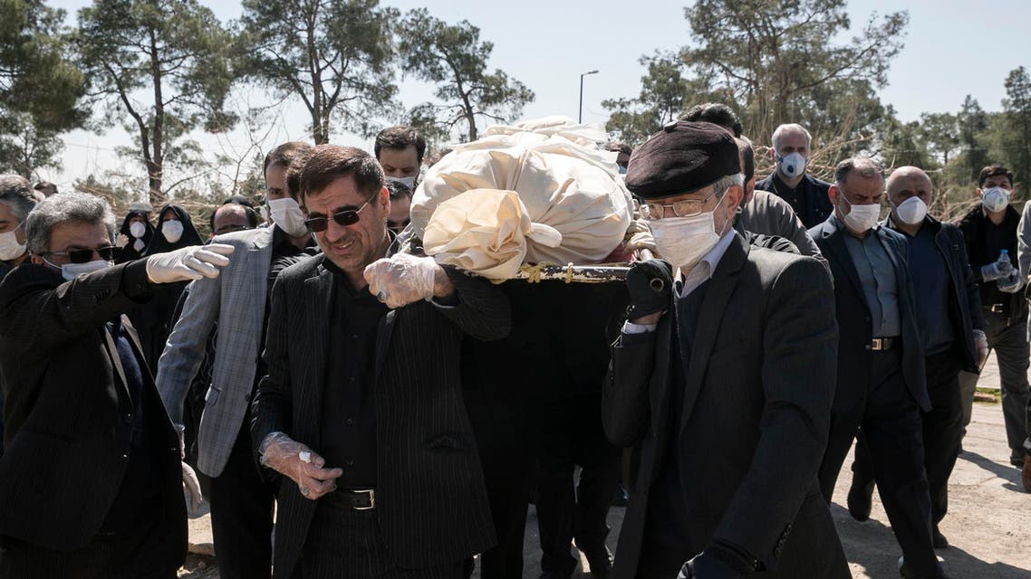 Mourners wearing face masks and gloves carry the body of former politburo official in the Revolutionary Guard Farzad Tazari, who died Monday after being infected with the new coronavirus, at the Behesht-e-Zahra cemetery just outside Tehran, Iran, on Tuesday, March 10, 2020. (AP)