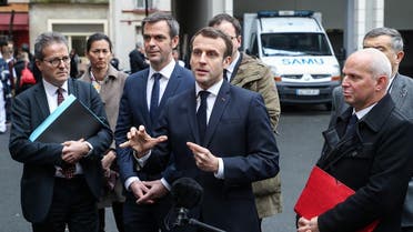 French President Emmanuel Macron speaks to the press as he leaves with (from L) AP-HP President Martin Hirsch, French Health and Solidarity Minister Olivier Veran, and French director general of health Jerome Salomon, after a visit of the SAMU-SMUR emergency services call center at the Necker Hospital on March 10, 2020 in Paris, focused on COVID-19 coronavirus outbreak. (AFP)
