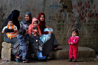 Syrian refugees women hold their children as they sit in Ouzai refugee compound, in the southern port city of Sidon, Lebanon. (File photo: AP)