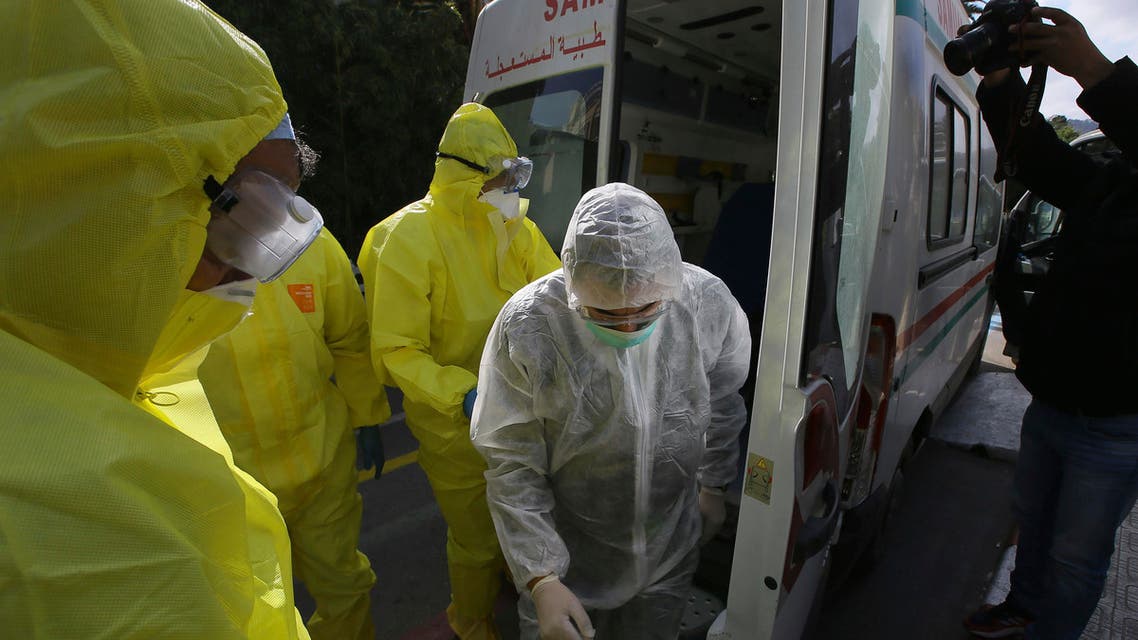 Medics stand outside a clinic where passengers and the crew of a flight went in for coronavirus tests, in Algeria, on Wednesday, February 26, 2020.