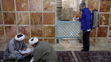 An Iranian sanitary worker disinfects Qom's Masumeh shrine on February 25, 2020. (AP)