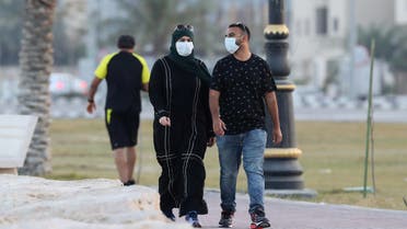 A couple wear a protective face mask, as they walk, after Saudi Arabia imposed a temporary lockdown on the province of Qatif, following the spread of coronavirus, in Qatif, Saudi Arabia, March 10, 2020. (Reuters)