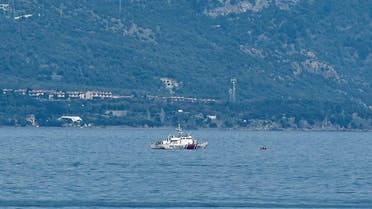 Turkish coastguard boat proceeds to check a inflatable boat at the sea between Lesbos island and the Turkish coast as part of operations to prevent boats of refugees of reaching the Greek coast on March 6, 2020. (AFP)