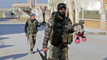 A Turkey-backed Syrian fighter holds a stuffed toy in the town of Saraqib in the eastern part of the Idlib province in northwestern Syria, on February 27, 2020. Syrian rebels reentered the key northwestern crossroads town of Saraqib lost to government forces earlier this month but fierce fighting raged on in its outskirts today, an AFP correspondent reported.