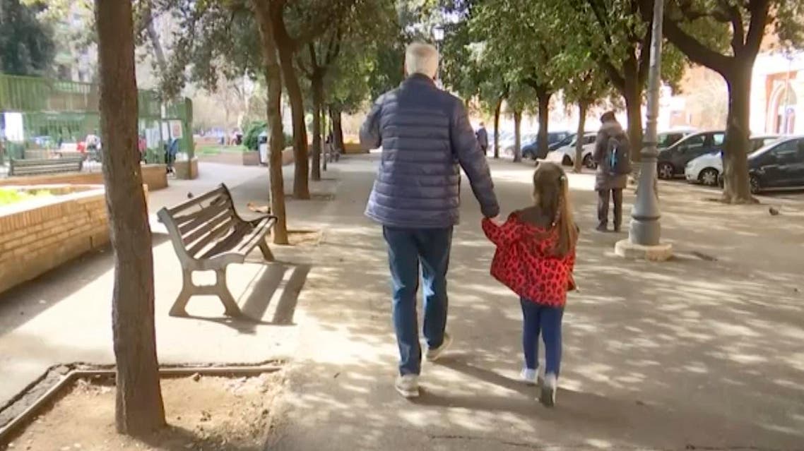 A young girl walk with her elderly grandparent along a tree lined avenue in Rome, Italy. (AP)
