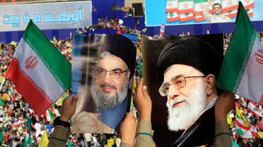 Two boys carry pictures of Hezbollah leader Hassan Nasrallah, left, and Iranian Supreme Leader Ayatollah Ali Khamenei, right, as thousands of Hezbollah supporters gather in a soccer field to listen to Iranian President Mahmoud Ahmadinejad 's speech during a rally in the southern town of Bint Jbeil, Lebanon on Oct. 14, 2010. (AP)