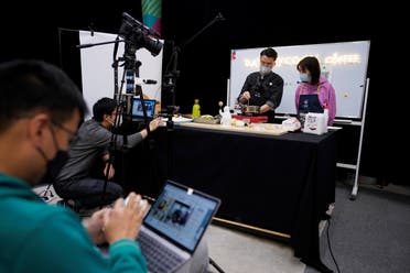 Chefs wearing face masks conduct a cooking lesson through a live-streaming session inside a restaurant at a office as the country is hit by an outbreak of the novel coronavirus that can cause COVID-19 disease, in Shanghai, China March 9, 2020. (Reuters)