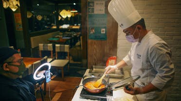 Chef wearing a face mask conducts a cooking lesson through a live-streaming session inside a restaurant at a shopping complex, as the country is hit by an outbreak of the novel coronavirus (COVID-19), in Tianjin. (Reuters)