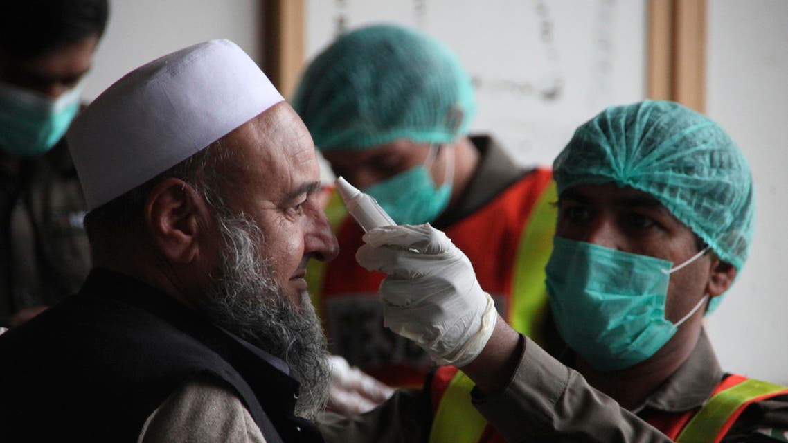 A health official of an emergency rescue service checks the body temperature of a government employee in Peshawar, Pakistan, on March 12, 2020. (AP)