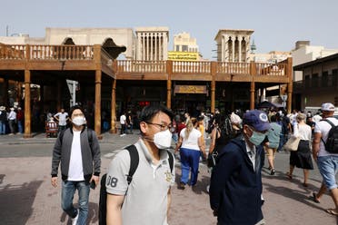 Tourists wear protective face masks as they walk at the Grand Souq in old Dubai. (Reuters)