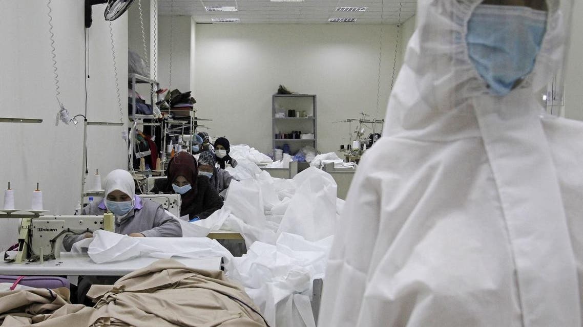 Workers produce protective clothing at a textile factory in the southern Lebanese city of Sidon on March 14, 2020. (AFP)