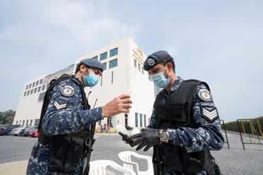 عناصر شرطة أمام فندق يقيم فيه أشخاص عائدون للكويت من إيران في إطار الحجر الصحي للتأكد من خلوهم من فيروس كورونا